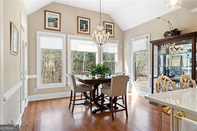 4115 Gold Mill Rdg, Canton, GA 30114 - dining area featuring vaulted ceiling, a chandelier, wood finished floors, and baseboards