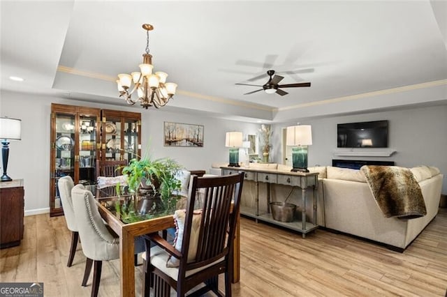 4115 Gold Mill Rdg, Canton, GA 30114 - dining space featuring a raised ceiling, light wood-style flooring, a ceiling fan, a chandelier, and ornamental molding