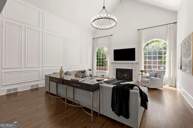 5120 Falcon Chase Ln, Atlanta, GA 30342 - living room featuring healthy amount of natural light, dark wood finished floors, a decorative wall, a chandelier, and high vaulted ceiling