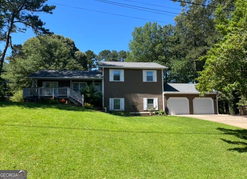 710 Wind Song Trce, Woodstock, GA 30189 - tri-level home featuring an attached garage, a front yard, and concrete driveway