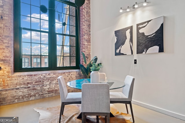 170 Boulevard E414, Atlanta, GA 30312 - dining space with concrete flooring, a high ceiling, and brick wall