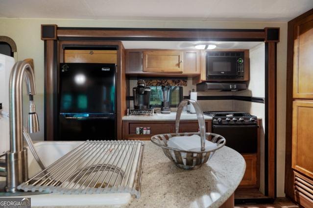 44 11th St, Ellijay, GA 30540 - kitchen with black appliances and light stone counters
