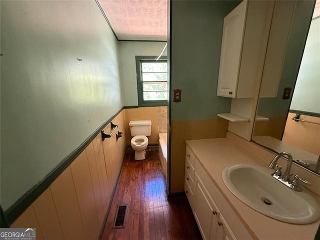 1272 Cave Springs Rd, Douglasville, GA 30134 - bathroom featuring wood finished floors, toilet, vanity, a tub to relax in, and a shower