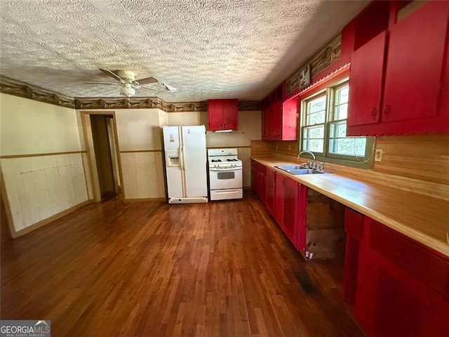 1272 Cave Springs Rd, Douglasville, GA 30134 - kitchen with white appliances, red cabinetry, a sink, a textured ceiling, and a wainscoted wall