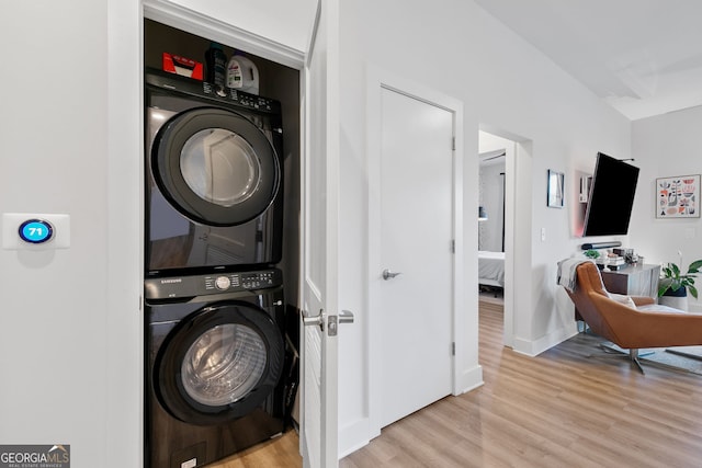 112 Rogers St NE Unit 410, Atlanta, GA 30317 - laundry room with stacked washer and clothes dryer, wood finished floors, and baseboards