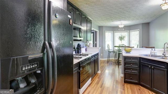 118 Valleyside Dr, Dallas, GA 30157 - kitchen with black fridge, a sink, stainless steel microwave, gas range oven, and light countertops