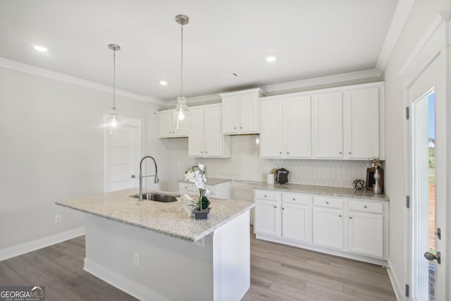 5344 Milford Dr Unit 183A, Gainesville, GA 30507 - kitchen featuring a sink, decorative backsplash, ornamental molding, white cabinets, and an island with sink