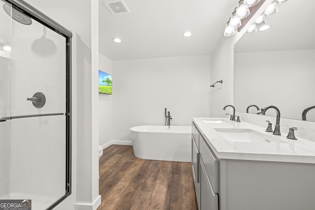 1935 Sam Bell Rd, Clarkesville, GA 30523 - bathroom featuring a shower stall, wood finished floors, double vanity, a freestanding tub, and recessed lighting