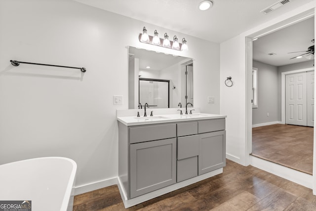 1935 Sam Bell Rd, Clarkesville, GA 30523 - bathroom with double vanity, a shower stall, wood finished floors, a freestanding tub, and recessed lighting