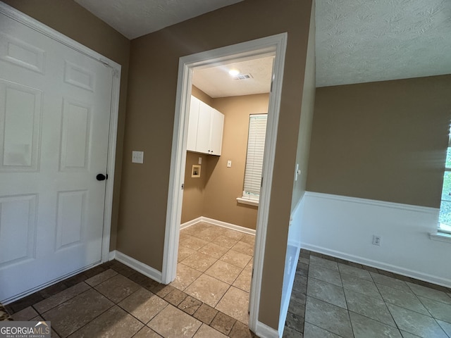 1280 Waterwood Dr, Loganville, GA 30052 - laundry room with tile patterned flooring, baseboards, and a textured ceiling