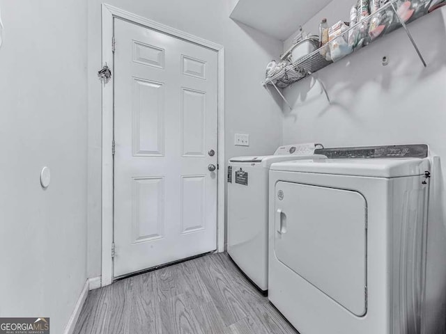 3931 Upper Bethany Rd, Ball Ground, GA 30107 - laundry room featuring washing machine and clothes dryer, light wood-style floors, and baseboards