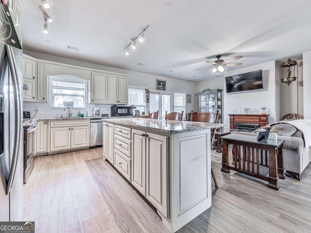 3931 Upper Bethany Rd, Ball Ground, GA 30107 - kitchen with stainless steel appliances, ceiling fan, a kitchen island, a sink, and light wood finished floors
