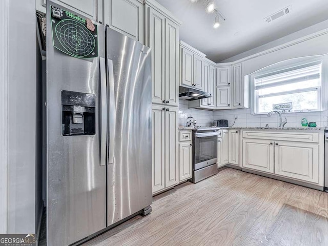 3931 Upper Bethany Rd, Ball Ground, GA 30107 - kitchen with appliances with stainless steel finishes, under cabinet range hood, light wood finished floors, a sink, and light stone counters