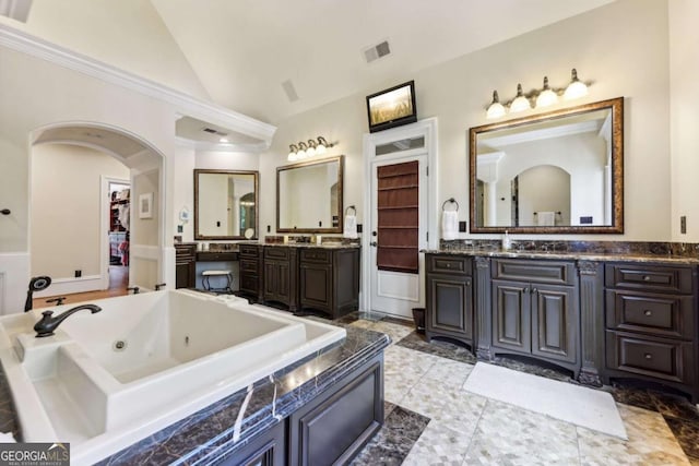 6678 Gaines Ferry Rd, Flowery Branch, GA 30542 - full bath with vaulted ceiling, two vanities, a tub with jets, and crown molding