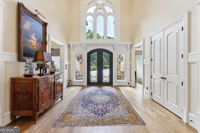 6678 Gaines Ferry Rd, Flowery Branch, GA 30542 - foyer featuring a towering ceiling, french doors, light wood-style floors, and a decorative wall