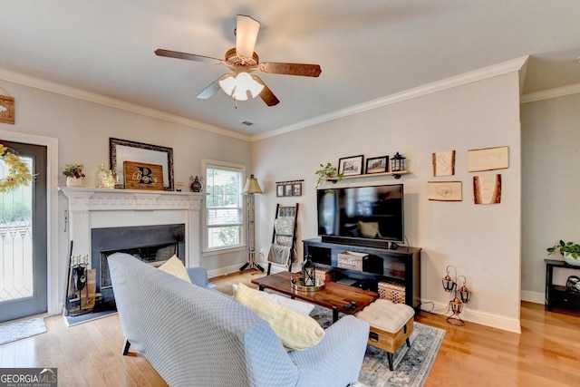2469 Martini Way, Bethlehem, GA 30620 - living area featuring light wood-style floors, a fireplace with raised hearth, a ceiling fan, baseboards, and crown molding