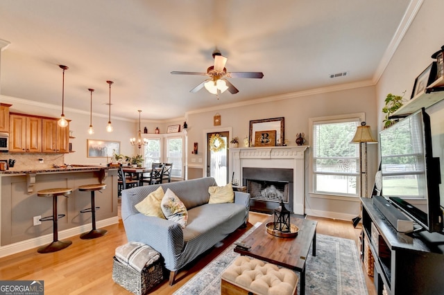 2469 Martini Way, Bethlehem, GA 30620 - living room with healthy amount of natural light, light wood-style floors, a ceiling fan, a fireplace, and crown molding
