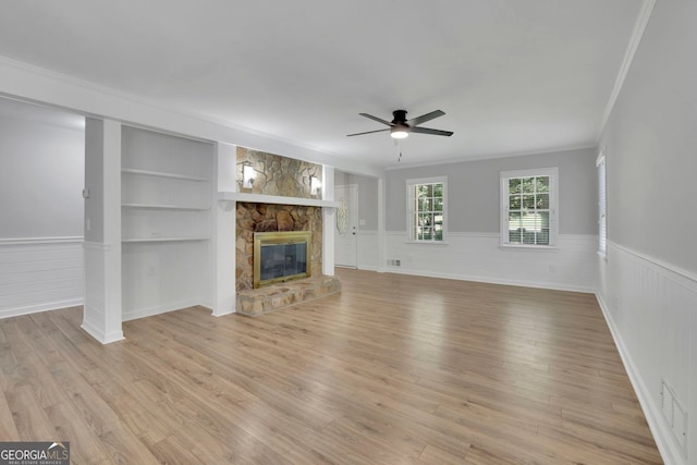 4516 Creekwood Cir NW, Kennesaw, GA 30152 - unfurnished living room with ceiling fan, a wainscoted wall, crown molding, built in shelves, and light wood-type flooring