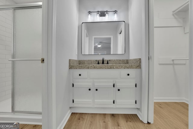 4516 Creekwood Cir NW, Kennesaw, GA 30152 - bathroom featuring wood finished floors, a shower stall, vanity, and baseboards