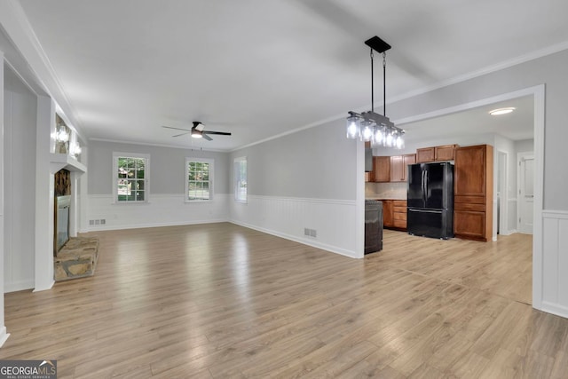 4516 Creekwood Cir NW, Kennesaw, GA 30152 - unfurnished living room featuring a ceiling fan, ornamental molding, wainscoting, light wood-style flooring, and a glass covered fireplace