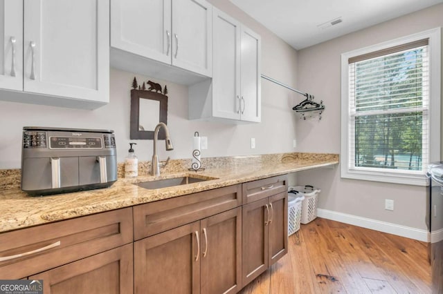 117 Valley View Ct, Blairsville, GA 30512 - kitchen featuring a sink, baseboards, light wood-style flooring, light stone counters, and white cabinetry