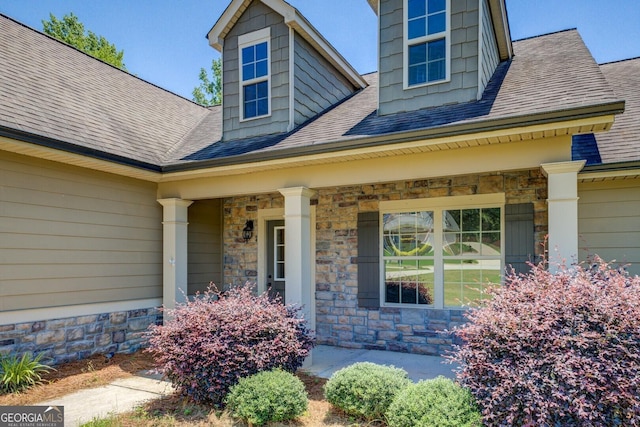 70 Country Meadows Ln, Covington, GA 30014 - view of exterior entry featuring stone siding, covered porch, and a shingled roof