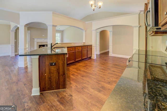 70 Country Meadows Ln, Covington, GA 30014 - kitchen with a sink, brown cabinets, dark wood finished floors, a fireplace, and open floor plan