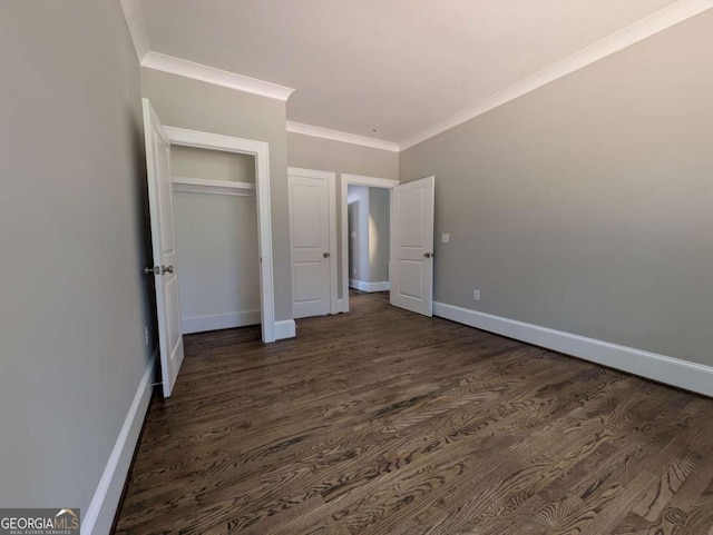 8239 High Lake Ter, Covington, GA 30014 - unfurnished bedroom with dark wood-type flooring, baseboards, ornamental molding, and a closet