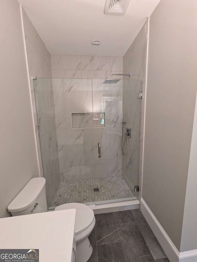 8239 High Lake Ter, Covington, GA 30014 - bathroom with toilet, a marble finish shower, marble look tile flooring, and baseboards