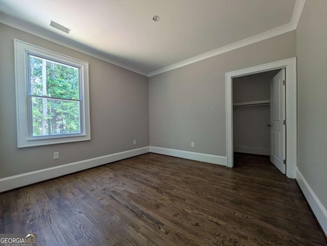 8239 High Lake Ter, Covington, GA 30014 - unfurnished bedroom with crown molding, baseboards, dark wood-type flooring, a walk in closet, and a closet