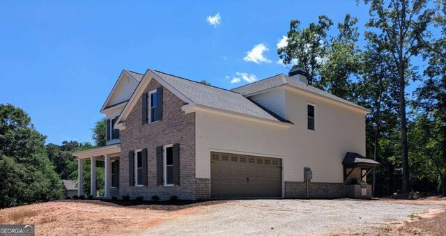 8239 High Lake Ter, Covington, GA 30014 - view of side of home featuring brick siding, dirt driveway, and a chimney