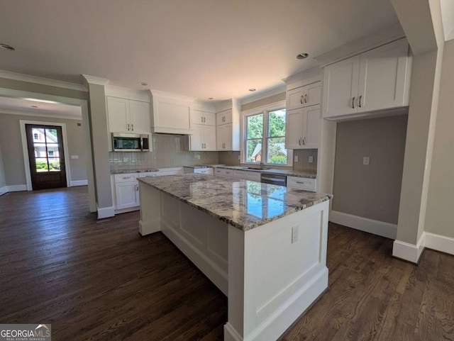 8239 High Lake Ter, Covington, GA 30014 - kitchen with appliances with stainless steel finishes, baseboards, white cabinets, light stone counters, and crown molding
