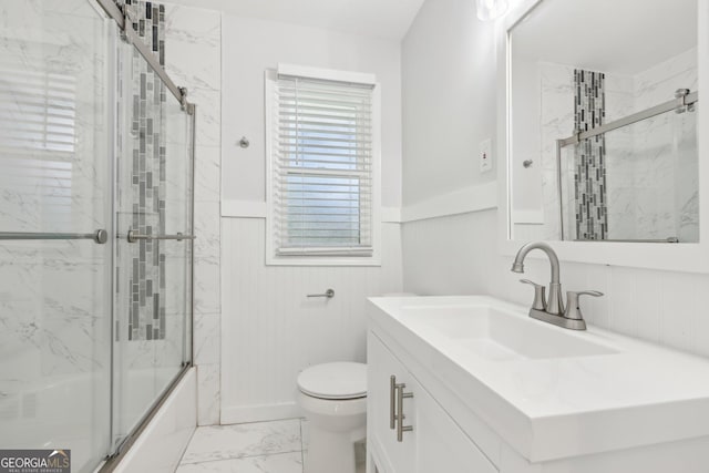 623 Montevista St SW, Atlanta, GA 30310 - full bathroom with marble look tile flooring, toilet, vanity, a wainscoted wall, and shower / bath combination with glass door
