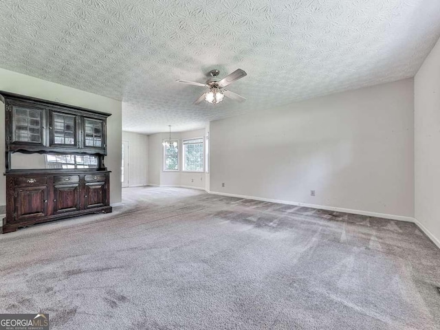 301 Jetta Ln, Canton, GA 30115 - unfurnished living room featuring baseboards, ceiling fan, carpet floors, a textured ceiling, and a chandelier