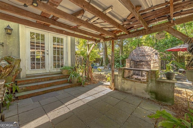 3 Stewart Ave, Saint Simons, GA 31522 - view of patio with french doors and an outdoor stone fireplace