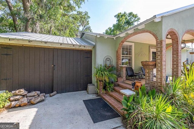 3 Stewart Ave, Saint Simons, GA 31522 - property entrance with stucco siding, covered porch, and metal roof