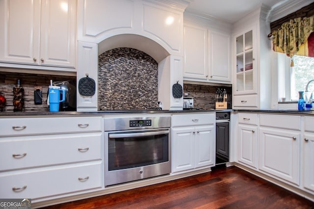 1050 Denton Rd, Douglasville, GA 30134 - kitchen featuring stainless steel oven, dark countertops, backsplash, glass insert cabinets, and white cabinets