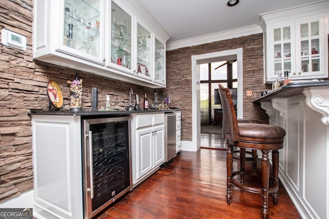 1050 Denton Rd, Douglasville, GA 30134 - indoor wet bar with beverage cooler, crown molding, and dark wood-type flooring