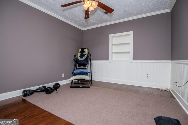 1050 Denton Rd, Douglasville, GA 30134 - exercise room with built in shelves, wainscoting, a textured ceiling, a ceiling fan, and crown molding