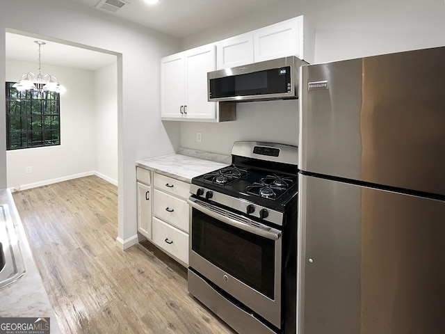 3008 Pine Tree Trl # 16D, South Fulton, GA 30349 - kitchen with appliances with stainless steel finishes, light wood-style flooring, white cabinetry, a chandelier, and light countertops
