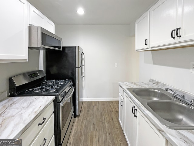 3008 Pine Tree Trl # 16D, South Fulton, GA 30349 - kitchen featuring stainless steel appliances, a sink, light wood-style flooring, white cabinetry, and baseboards