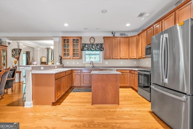413 Tuxedo Dr, Commerce, GA 30530 - kitchen featuring appliances with stainless steel finishes, a peninsula, crown molding, light countertops, and a center island