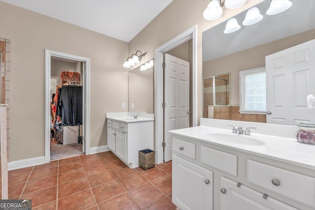413 Tuxedo Dr, Commerce, GA 30530 - full bathroom featuring tile patterned flooring, two vanities, tiled shower, a spacious closet, and baseboards