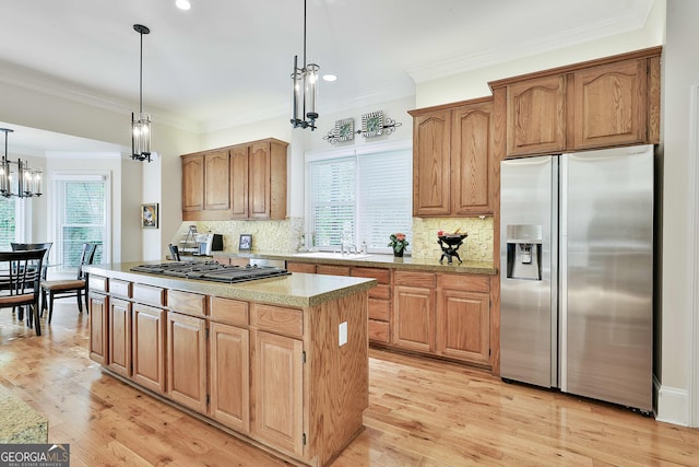 1000 Pleasance Grv, Peachtree City, GA 30269 - kitchen featuring stainless steel refrigerator with ice dispenser, healthy amount of natural light, gas cooktop, a center island, and ornamental molding