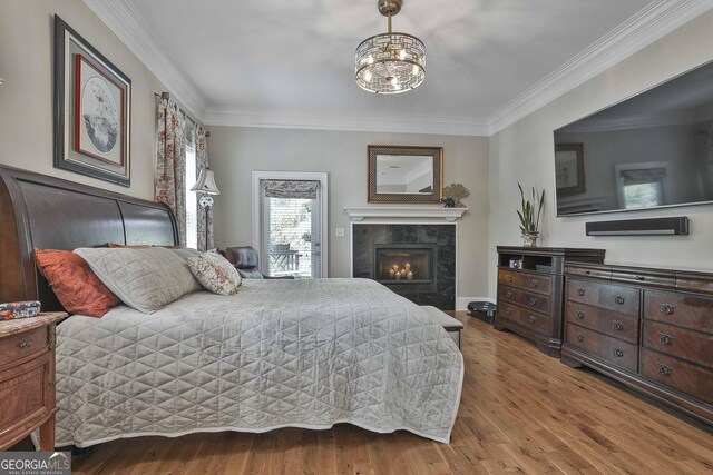 1000 Pleasance Grv, Peachtree City, GA 30269 - bedroom featuring crown molding, wood finished floors, a tiled fireplace, and a chandelier