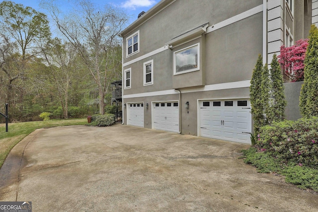 1000 Pleasance Grv, Peachtree City, GA 30269 - view of side of property with an attached garage, stucco siding, and driveway