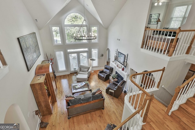 1000 Pleasance Grv, Peachtree City, GA 30269 - living area with high vaulted ceiling, wood finished floors, a chandelier, and stairway