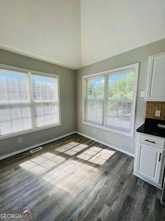 350 Fall View Ct, Winder, GA 30680 - unfurnished dining area featuring a textured ceiling, vaulted ceiling, and dark wood-style floors