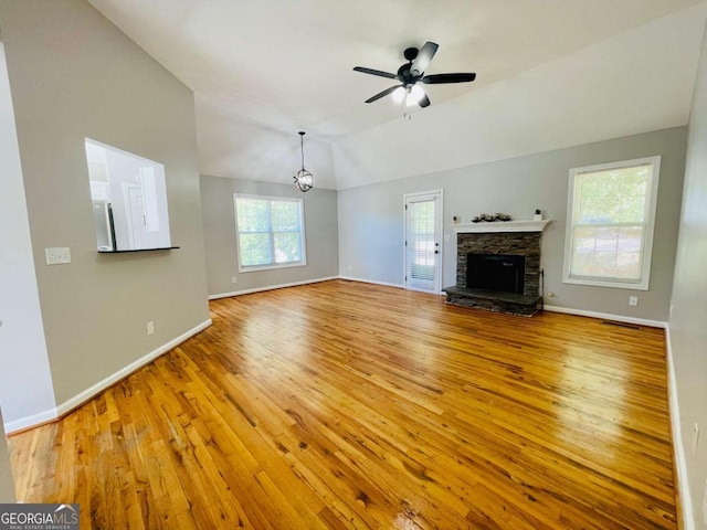 350 Fall View Ct, Winder, GA 30680 - unfurnished living room featuring wood-type flooring, ceiling fan, lofted ceiling, a fireplace, and a chandelier