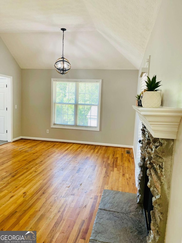 350 Fall View Ct, Winder, GA 30680 - living room featuring lofted ceiling, wood-type flooring, a chandelier, and a fireplace